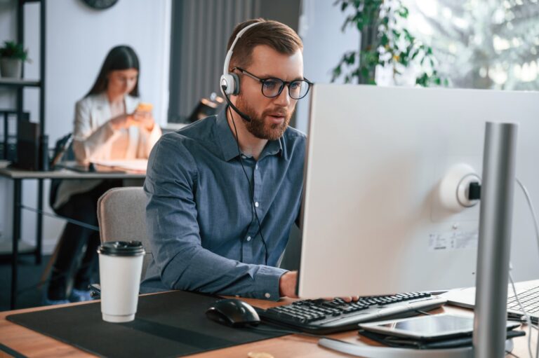 man-is-using-computer-two-employees-are-working-1920